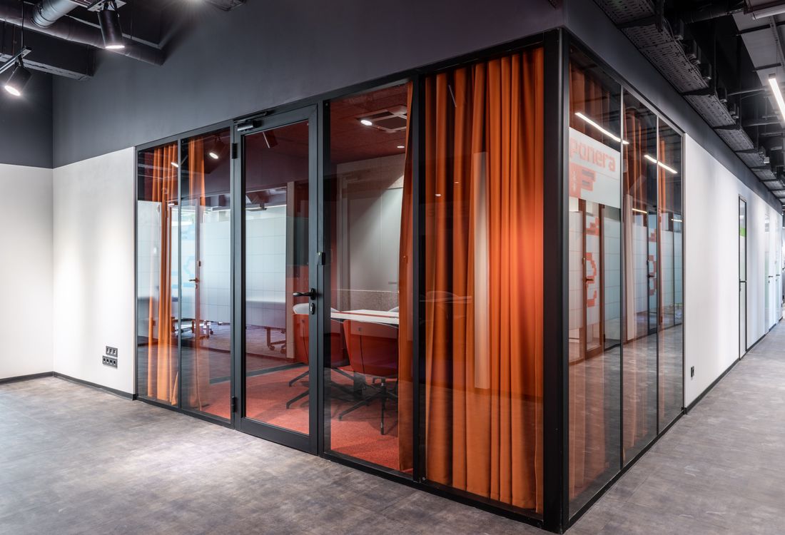 Commercial interior with glass-walled meeting rooms and coordinated finishes