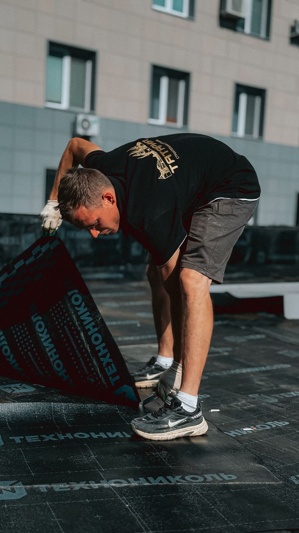 Roofer applying a waterproof membrane to a flat roof